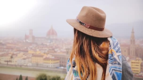 Portret van jonge mooie Kaukasische vrouw lachend gelukkig, blazen kussen kijken camera in Florence op een regenachtige dag. — Stockvideo