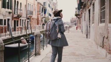 Mutlu beyaz kadın turist ile ünlü su canal sokağına Venedik İtalya etrafa bakıyor yürüyüş zevk fotoğraf makinesi.