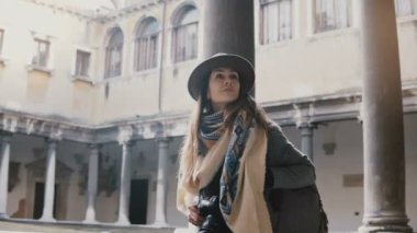 Güzel kadın turist ile yürüyüş ve Venedik antik sütunlar ile eski binanın terasında seyir fotoğraf makinesi.