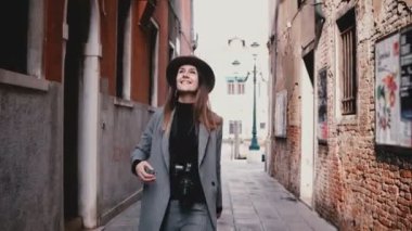 Çekici mutlu profesyonel kadın fotoğrafçı Venedik İtalya güzel eski cadde boyunca gülümseyen kamera ile yürüme
