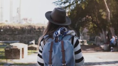 Kamera güzel Forum Roma kalıntıları tatil seyahat sırasında zevk sırt çantası ile genç kadın turist izler.