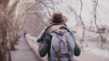 Arkadan görünüşü kadın turist ile inanılmaz uçak ağaçlar nehir banka soğuk geç sonbahar yavaş hareket boyunca yürüyüş sırt çantası.
