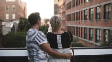Güzel genç romantik çift ayakta ve üzerinde bir köprü konuşuyor, şaşırtıcı New York'ta sahne zevk sarılma.