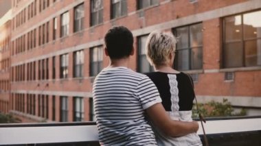 Güzel genç adam ve duran ve üzerinde bir köprü konuşuyor, sarılma kadının muhteşem şehir manzarası ve binalar.