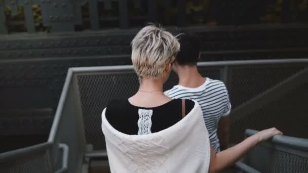 Красиві щасливі романтична пара спускаючись металеві сходи Нью-Йорку, тримаючись за руки, насолоджуючись дата ніч за межами. — стокове відео