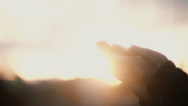 Vista de cerca de las manos femeninas sosteniendo el teléfono inteligente, de pie fuera en la puesta del sol. Mujer usando la pantalla táctil . — Vídeos de Stock
