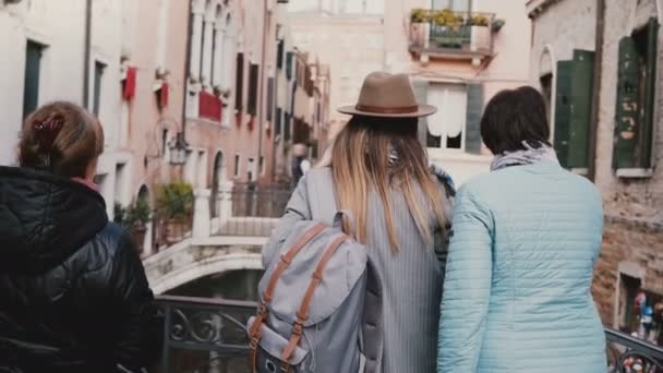 Vista posterior joven hija y madre mayor de pie juntos en el puente del canal disfrutando de la vista de vacaciones en Venecia Italia . — Vídeo de stock