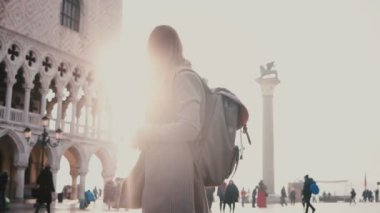 Mutlu kadın turist güneş ışığı Mercek parlaması ile Venedik İtalya San Marco meydanında şaşırtıcı smartphone fotoğraf çekmek.
