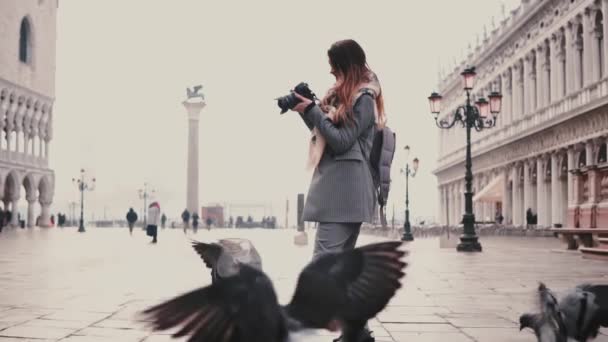 Felice fotografa donna con macchina fotografica passeggia su Piazza San Marco e stormo di piccioni a Venezia, scatta foto al rallentatore — Video Stock