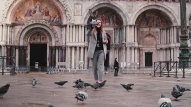 Smartphone ve güvercinler Venedik, İtalya, ağır çekimde San Marco Meydanı'nda el ile mutlu güzel kadın turist.