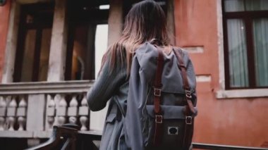 Kamera güzel gülümseyen turist kadın alarak fotoğraf eski Venedik sokak ağır çekimde profesyonel kamera ile takip eder.