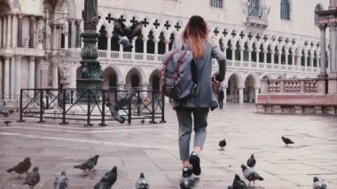 Arkadan görünüm silah Venedik ağır çekimde oturan güvercin ile kare San makro moda kadın turist yürür mutlu.