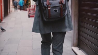 Kamera Venedik yavaş eski sokakta yürüyen sırt çantası ile takım elbise şık iş kadını turist izler.