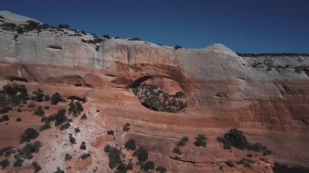 Incrível tiro panning aéreo de buraco incrível na montanha rochosa, turistas explorando incríveis Arcos no parque nacional . — Vídeo de Stock