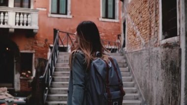 Kamera fotoğraf ağır çekim alarak fotoğraf makinesi ile Venedik sokak, merdivenlerde yürüyen güzel seyahat blogger kadın izler