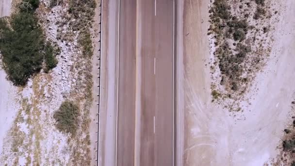 Vista superior drone zoom en camión blanco va por cámara en carretera hermosa carretera en medio del desierto de piedra arenisca . — Vídeo de stock