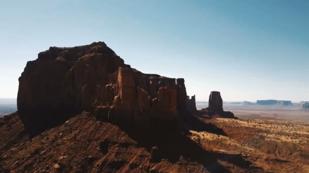 Dronen flyr mot det episke steinfjellet i Monuments Valley nasjonalpark. Fantastisk sandsteinslagt skyline. . – stockvideo