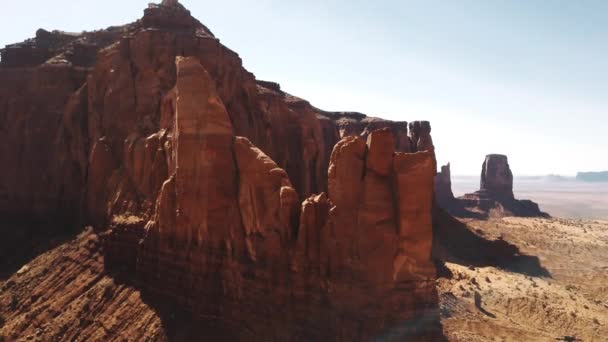 Dron volando alto alrededor de una gran montaña rocosa en medio del desierto de arenisca y el cielo azul en la reserva nacional americana . — Vídeo de stock