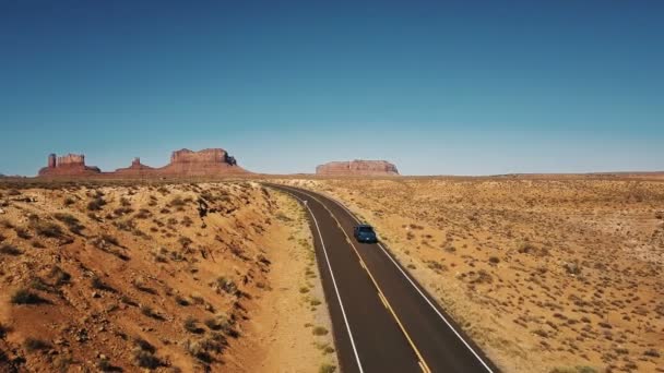 Blå pickup bil förbi drone kamera på tomma öde motorväg väg i Arizona med fantastisk platta bergen skyline. — Stockvideo