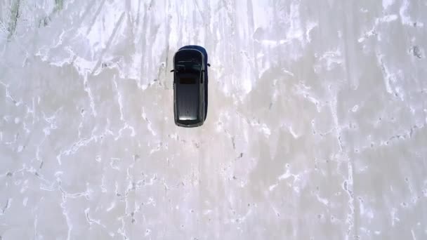 Top view aerial drone shot of silver minivan car driving along incredible salt lake desert plain with amazing texture. — Stock Video