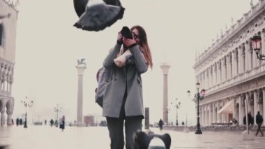 Kamera ile mutlu kadın fotoğrafçı güvercinler akın Venedik San Marco meydanında ağır çekim gülümseyen fotoğraflarını çeker.