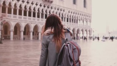 Venedik, İtalya, eski San Marco Kent Meydanı şaşırtıcı üzerinde yürüyüş güzel genç kadın turist geri yavaş hareket arıyorsunuz.