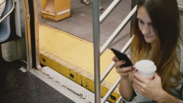 Hög vinkel kamera på attraktiva unga europeiska kvinna i tunnelbanan träna med smartphone, bildörrar utgående plattform. — Stockvideo