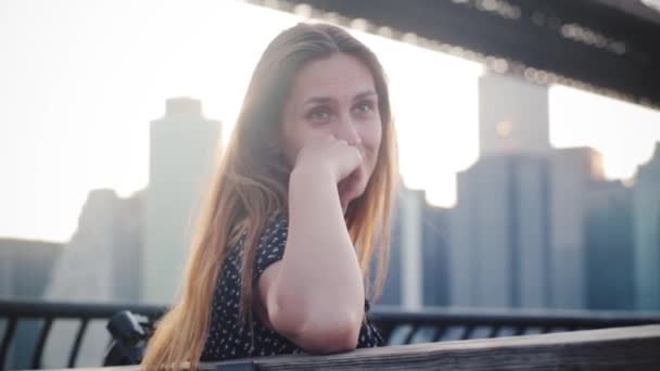 Increíble retrato de cerca de una mujer europea feliz con el pelo largo escuchando a un amigo en el horizonte del puente de Manhattan . — Vídeo de stock