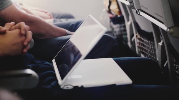Homem de negócios de passageiros de avião de visão lateral assistindo filmes durante um voo de avião usando dispositivo de vídeo player portátil . — Vídeo de Stock