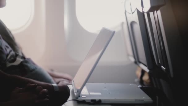 Närbild sidovy av uttråkad plan passagerare titta på video under en lång planet flygningen använder mobila videospelare enhet. — Stockvideo