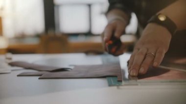 Bıçak ve üçgen cetvel ile tabloda büyük deri parça kesme yetenekli kadın esnaf güzel yakın çekim çekim eller