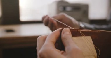 Erkek yakın çekim çekim ile hafif modern üretim Atölyesi iğneler dikiş el yapımı deri çanta Saraciye üzerinde eller.