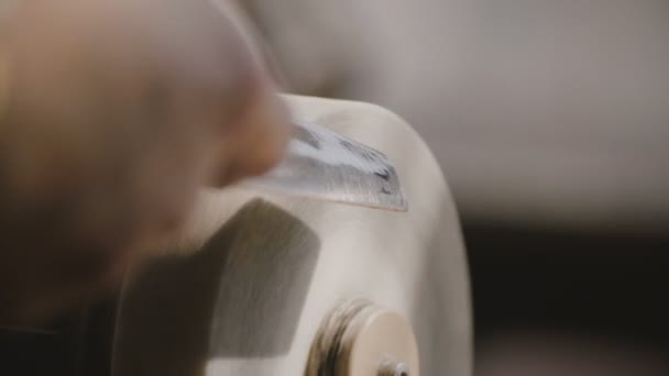 Beau plan rapproché des mains de technicien masculin à l'aide de l'outil de disque de rotation abrasif blanc pour aiguiser la vieille lame de couteau .