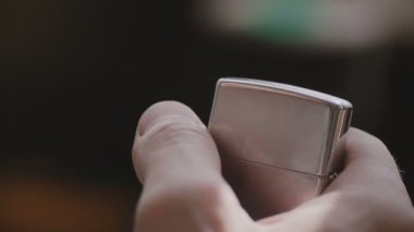 Güzel makro yakın çekim vintage Gümüş Metalik kıvılcım ve ateş elde çakmak, açılış erkek el vurdu.