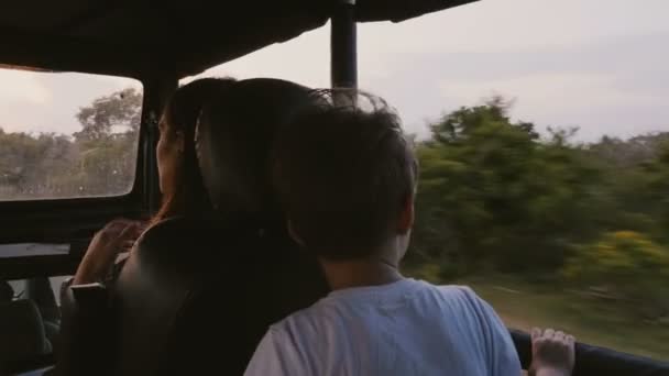 Feliz pequeña familia turística, madre y niño pequeño, disfrutando de un rápido paseo al atardecer en un coche de excursión de safari a lo largo del bosque salvaje . — Vídeos de Stock