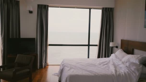 Camera zooms in on large modern comfortable hotel apartment window with incredible scenic cloudy ocean waves view. — Stock Video