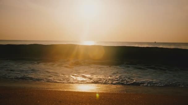 Mooie achtergrond lens flare schot van idyllische gouden zonsondergang op verbazingwekkende ocean resort strand, grote golf komt op. — Stockvideo