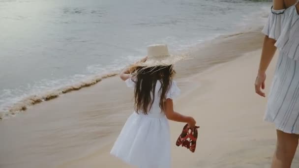 Volver vista de ángulo alto feliz hermosa madre joven caminando junto con dos niños a lo largo de la playa de arena atmosférica mar . — Vídeo de stock