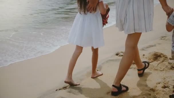 Cámara sigue feliz hermosa madre joven caminando junto con dos niños disfrutando de vacaciones exóticas en la playa del océano . — Vídeos de Stock