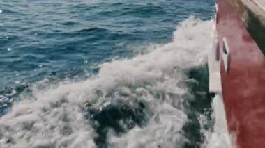 Güzel Pov shot, şaşırtıcı köpüklü beyaz dalgalar güneş ışığında parlayan kesme derin mavi denizde yelkenli gemi cruise.