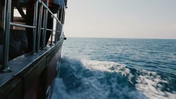Όμορφο πλάνο Pov του cruise βάρκα πλευρά ιστιοπλοΐα με γιοτ γρήγορα στην ανοικτή θάλασσα, κοπή λάμπει μπλε κύματα σαφή ηλιόλουστη ημέρα. — Αρχείο Βίντεο