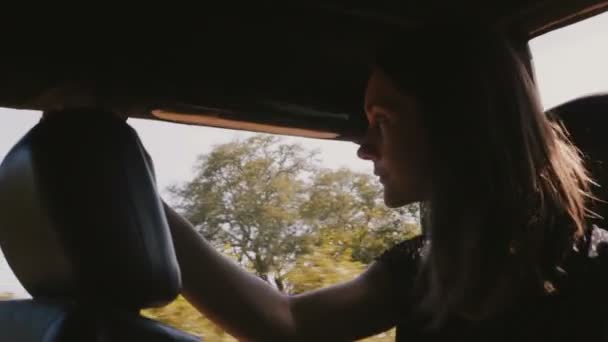 Jeune touriste heureuse souriante, profitant d'une belle balade en safari en voiture d'excursion le long de la forêt sauvage ensoleillée en vacances . — Video