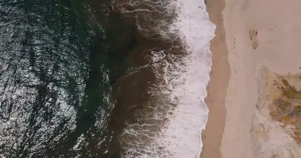 Повітряний вид зверху збільшити знімок красивих пігментних океанічних хвиль, що досягають сонячного екзотичного піщаного пляжу у великій сурогаті Каліфорнія . — стокове відео