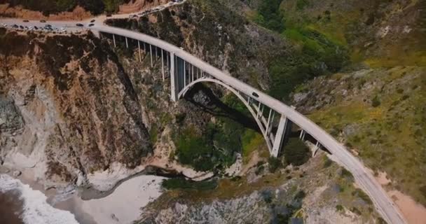 Şaşırtıcı üstten görünüm hava atış ikonik Bixby Creek köprü ve otoyol 1, epik seyahat hedef Big Sur ABD otomobil. — Stok video