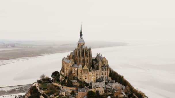 Drone flyger kvar runt Mont Saint Michel, berömda tid vatten ön stad och gamla resa landmärke vid dimmigt vitt hav. — Stockvideo