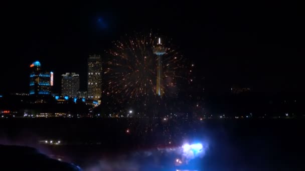 尼亚加拉瀑布2018年8月17日美丽的烟花在瀑布表面爆炸, 灯火通明的城市建筑慢动作. — 图库视频影像