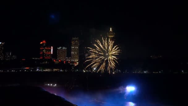 Niagarafälle 17. August 2018 schönes Feuerwerk explodiert über dunklem nächtlichen Wasserfall und beleuchteten Gebäuden Zeitlupe — Stockvideo