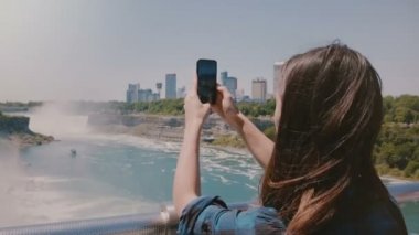İnanılmaz yavaş hareket arka görünümü mutlu genç turist kadın fotoğraf çekerken, epik Niagara Şelalesi şelale sahne zevk.