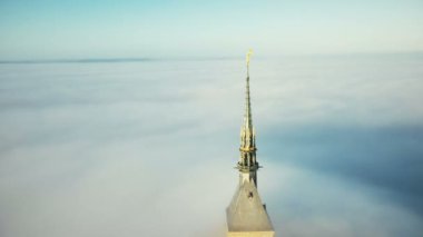 Drone bulutlar üzerinde güneşte parlayan Mont Saint Michel kale kale inanılmaz altın Abbey Spire etrafında uçan.