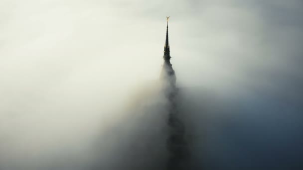 Vzdušný záběr z husté mlhy, pokrývající nádherný mystický hrad pevnosti Mont Saint Michel při východu slunce v Normandii. — Stock video